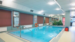 An indoor swimming pool with clear water, safety equipment, and a tiled floor. - Geovita Krynica Zdroj (Krynica-Zdroj)