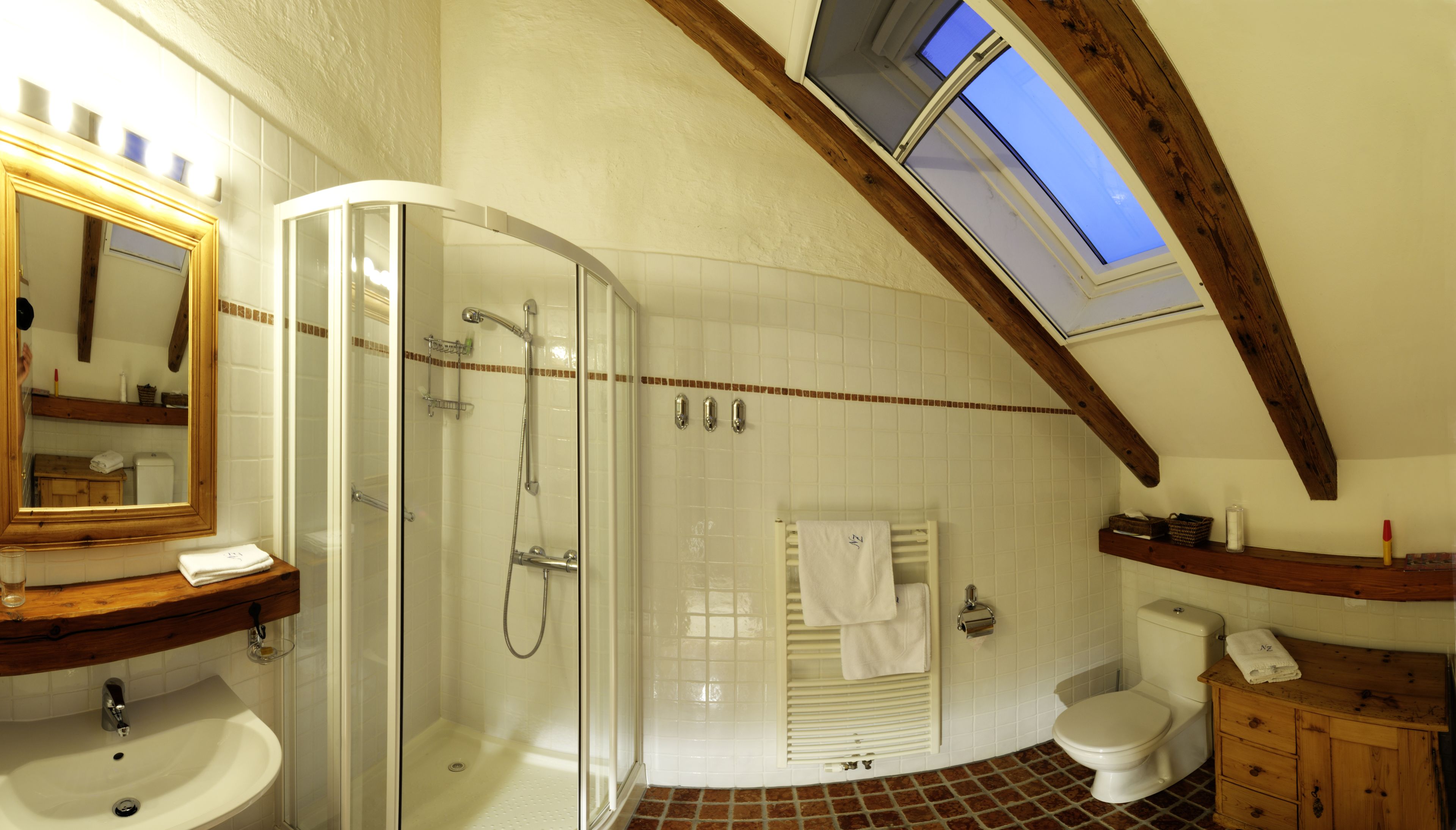 Ein Badezimmer mit einer Duschkabine, einem Waschbecken, einer Toilette und einem Schminktisch mit Spiegel.