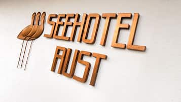 Puinen kyltti, jossa on teksti ”SEEHOTEL RUST” ja tyylitelty lintukuva.