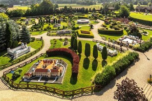 Un jardin aménagé avec un bâtiment central, des allées et une variété d’arbres et d’arbustes.