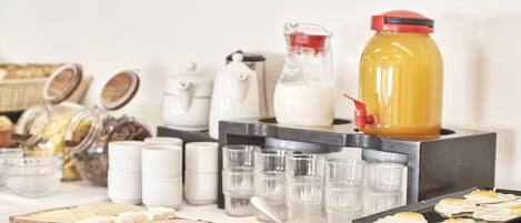 A breakfast buffet with various food items, including cheese, meats, and eggs, along with beverages and condiments.