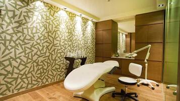 Relax in a serene space with a cushioned examination table, side table, and comfortable office chair.