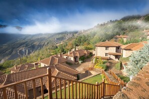 A hillside village with terracotta-roofed houses, a wooden staircase, and a view of the surrounding mountains. - Pliadon Gi Mountain Resort & Spa (Xylokastro-Evrostina)