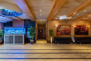 A reception area with a large aquarium, potted plants, and artwork on the walls. - Hotel Badura (Wadowice)