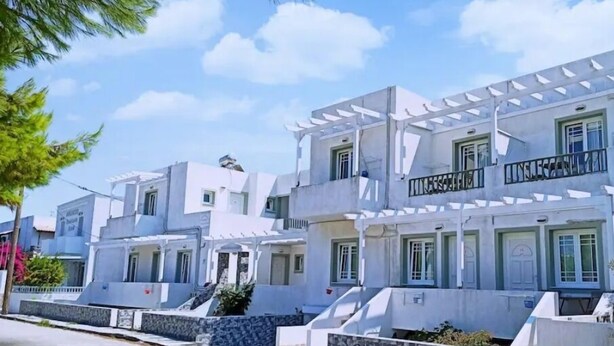 A row of modern, white buildings with balconies and a clear sky. - Atlantis Place Milos (Milos)