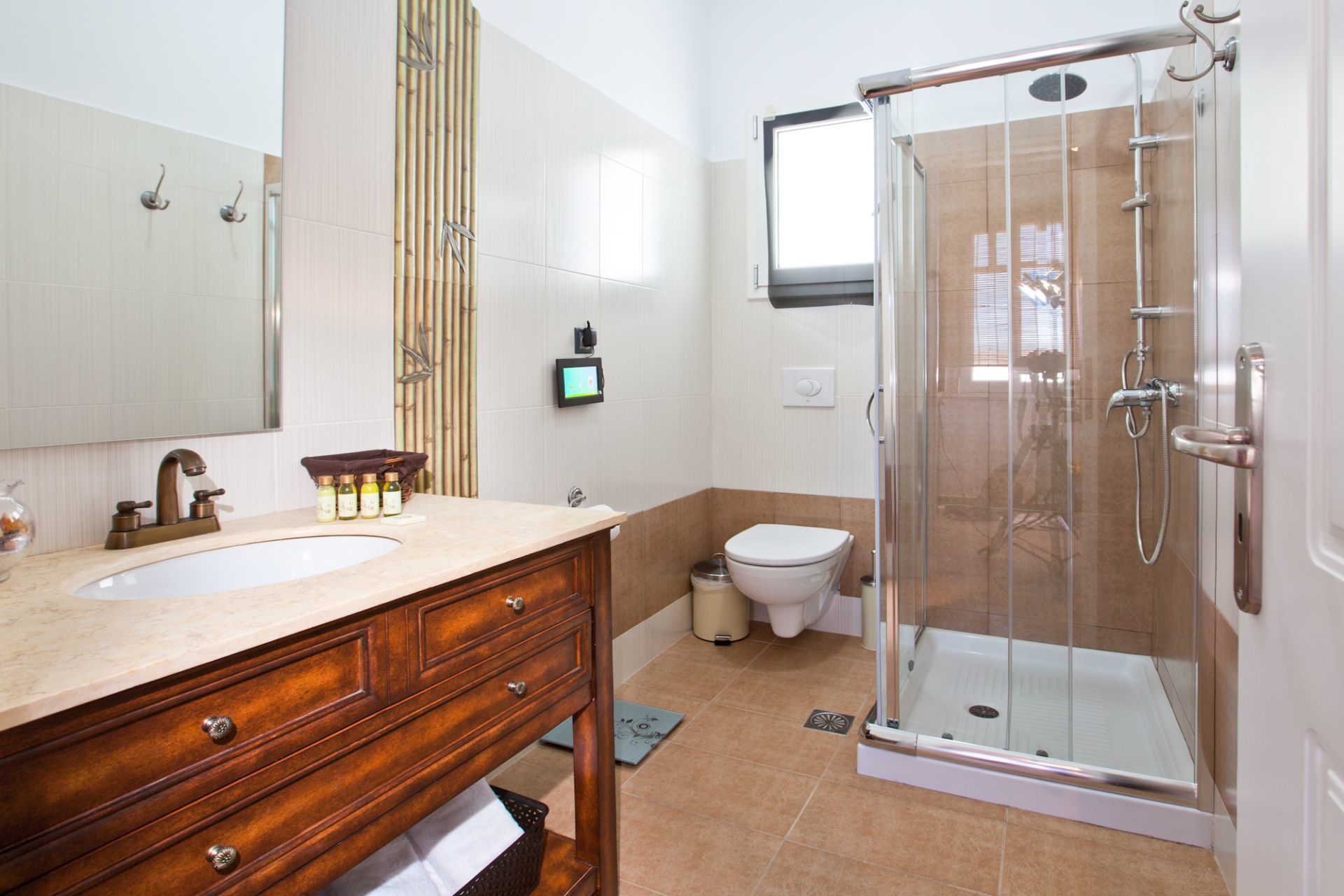 Une salle de bain moderne avec un meuble-lavabo en bois, une cabine de douche en verre et des toilettes.