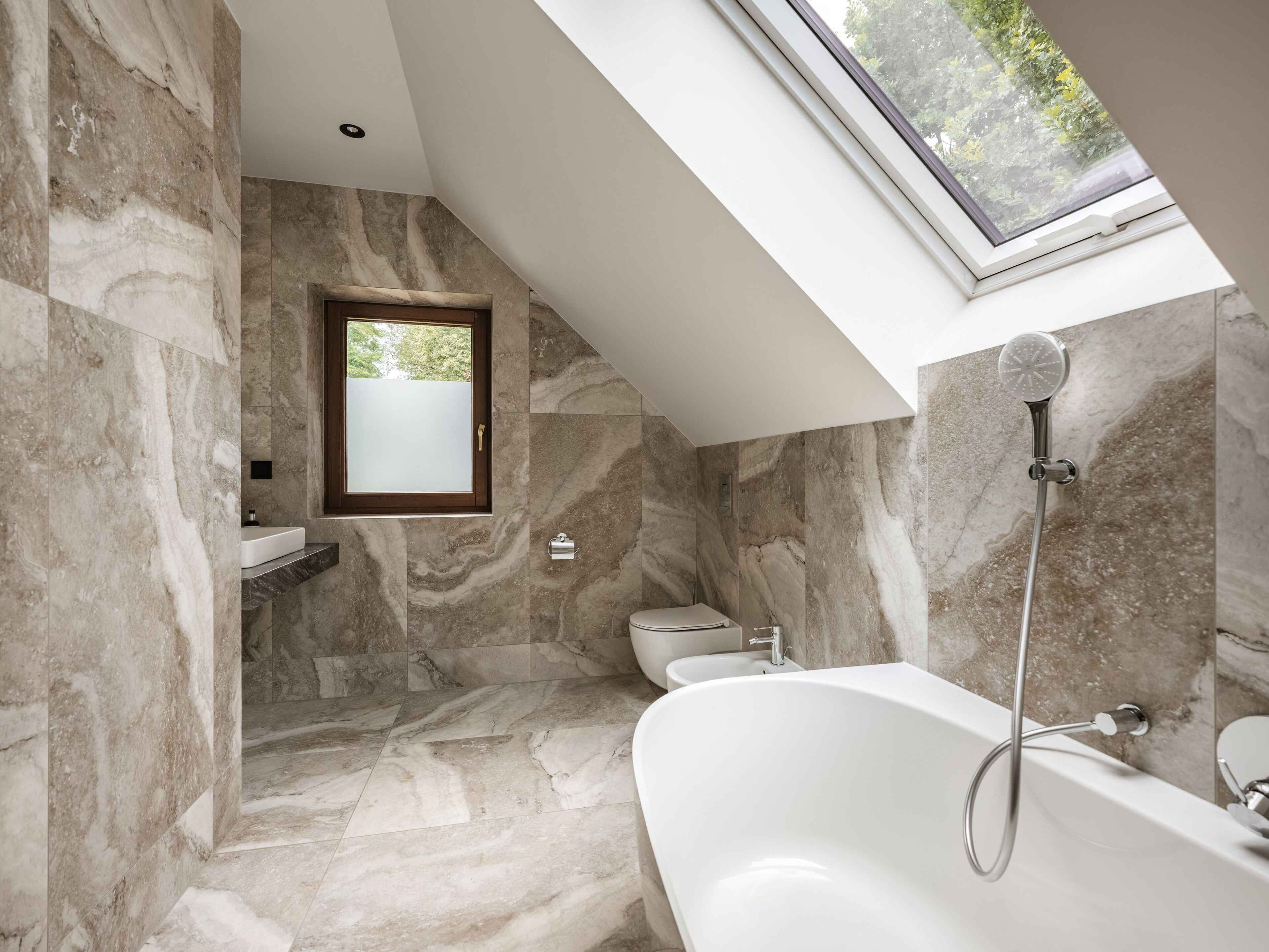 Un baño moderno con una bañera independiente, ducha y ventana con vidrio esmerilado.