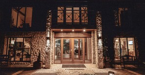 A stone building with a wooden entrance and a glass door. - Dwór w Tomaszowicach (Wielka Wies)