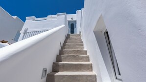 A white staircase leading to a door, surrounded by white walls. - Flaskos Luxury Suites (Mykonos)
