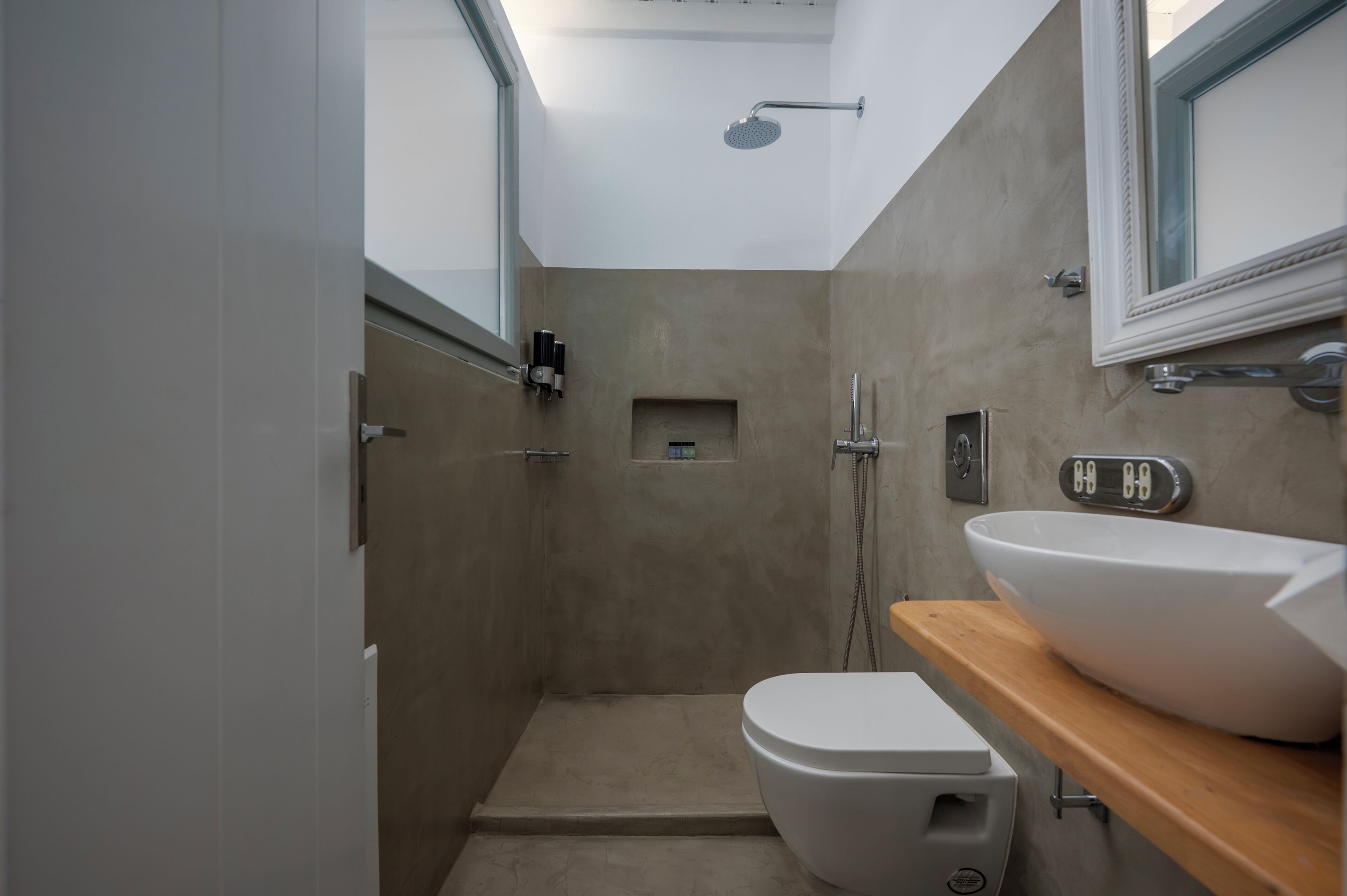 A modern bathroom with a shower, toilet, and sink.