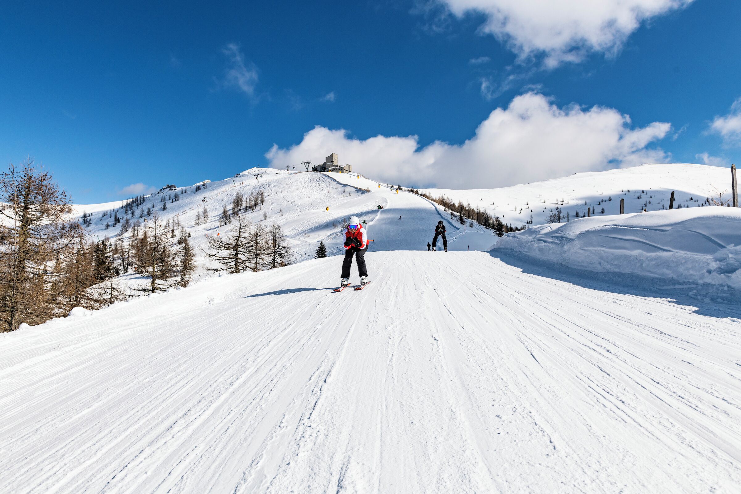 Een besneeuwde piste met skiërs.