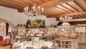 A buffet setup with various food items and a chandelier.