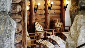 A log cabin interior with wooden chairs and stone walls.