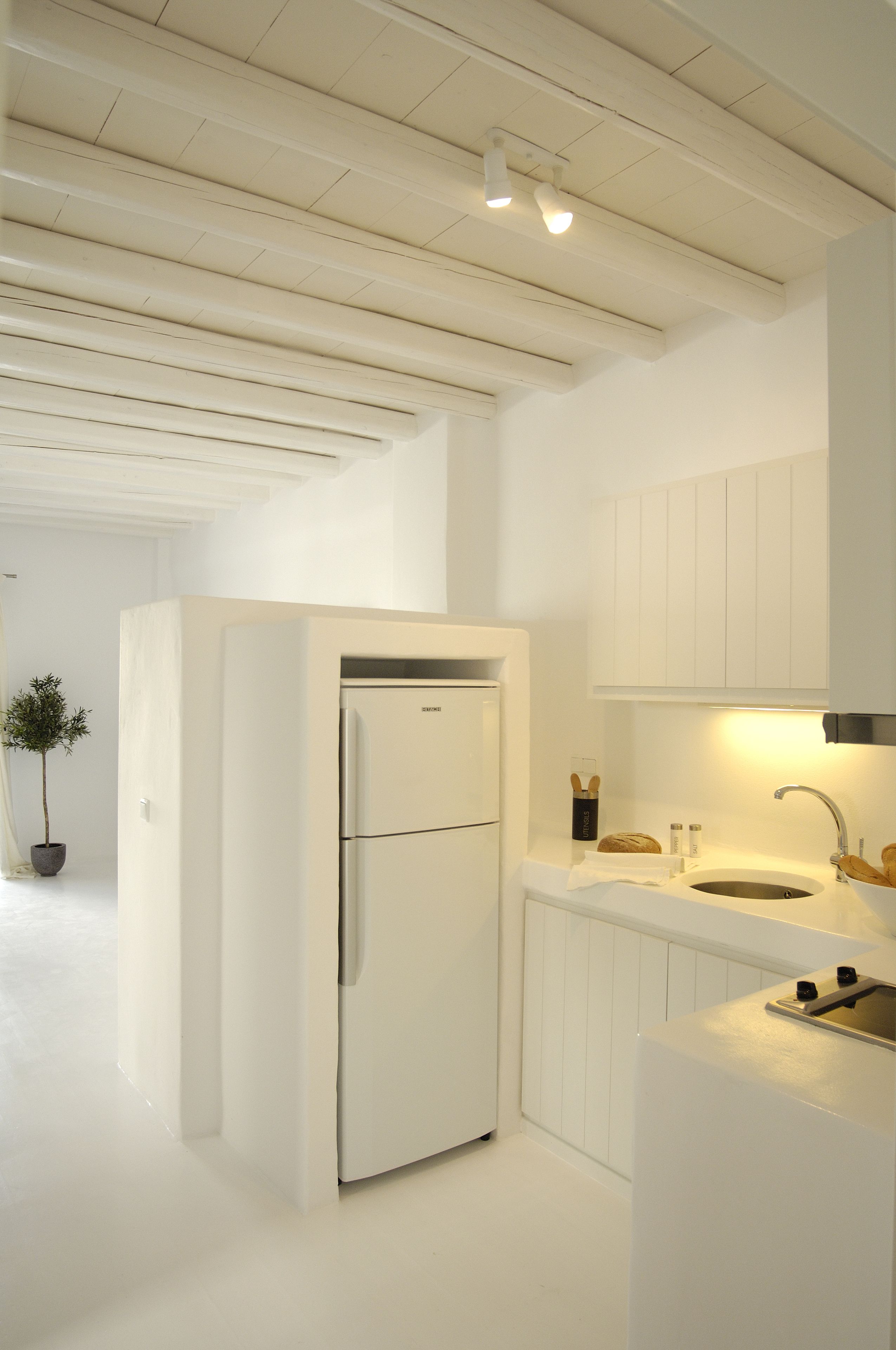 Een moderne keuken met witte kastjes, een geïntegreerde koelkast en een spoelbak.
