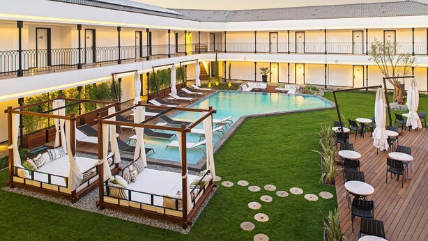 A hotel with a pool area, outdoor seating, and a covered garden space. - Mola Cunda Hotel (Ayvalik)