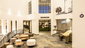 A spacious lobby with a staircase, seating areas, and a reception desk. - Mola Cunda Hotel (Ayvalik)
