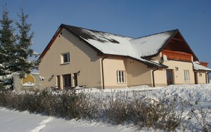 A two-story building with a sloped roof, a visible entrance, and a satellite dish. - Villa la Val (Kamienna Gora)