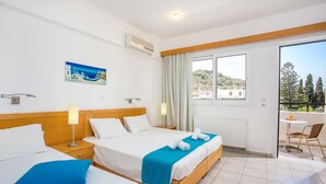 Une chambre d’hôtel avec deux lits, un balcon et une vue sur le paysage.