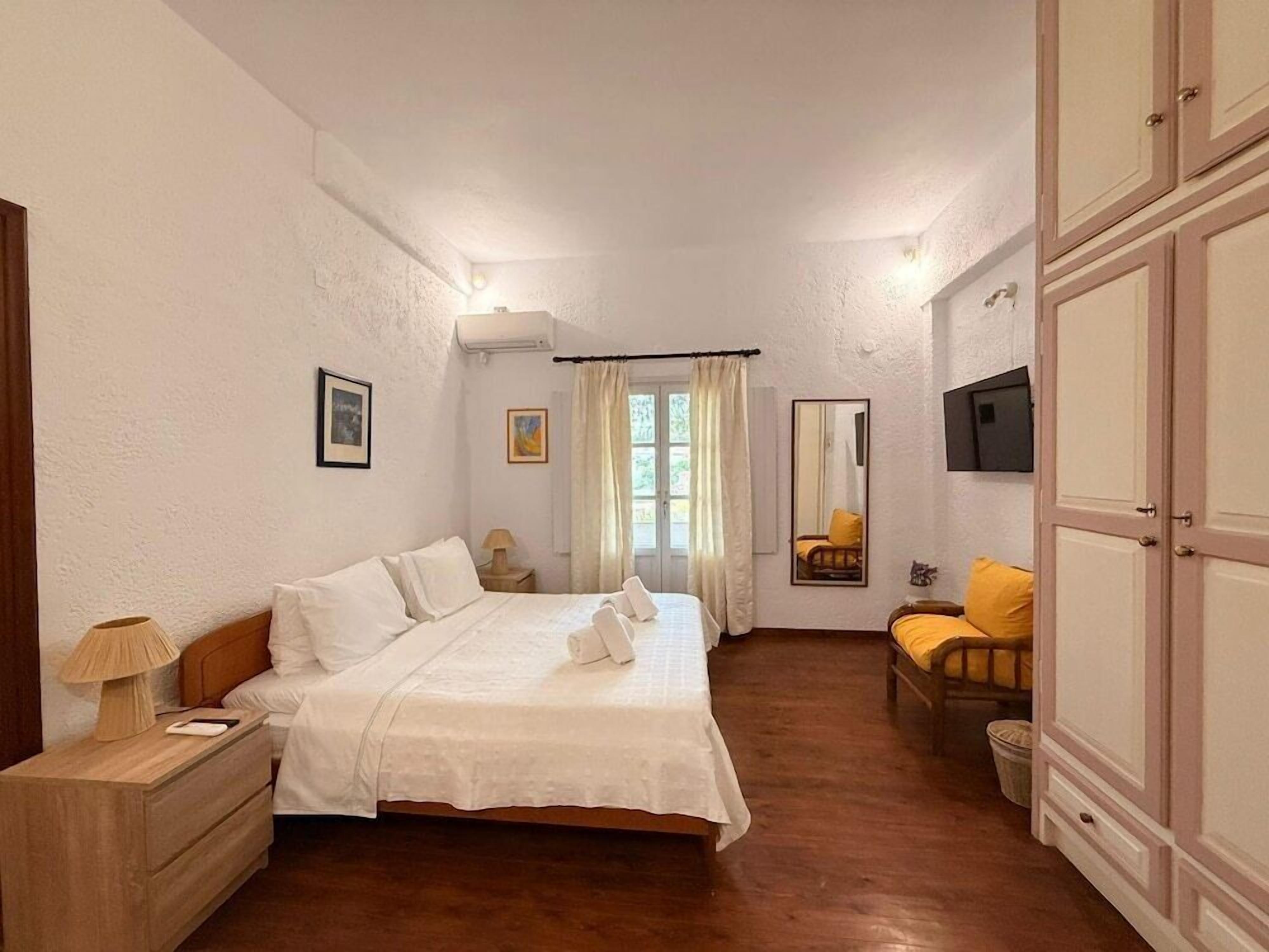 A bedroom with a bed, bedside tables, a mirror, and a wardrobe.