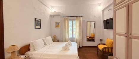 A bedroom with a bed, bedside tables, a mirror, and a wardrobe.