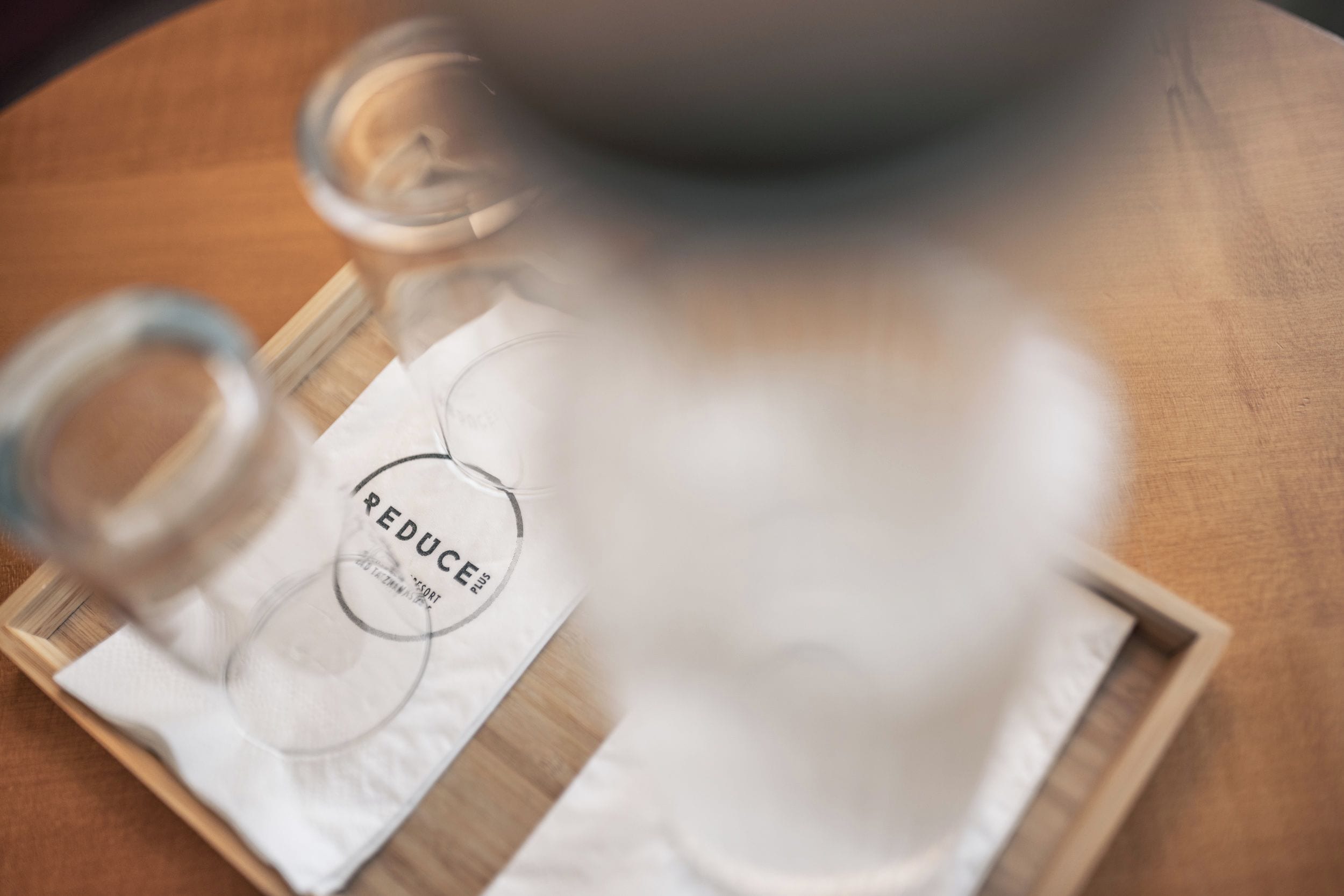 A wooden tray with a white napkin and a glass jar with a label.