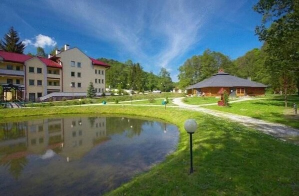 Un área residencial con un estanque, un pabellón y edificios de varios pisos.