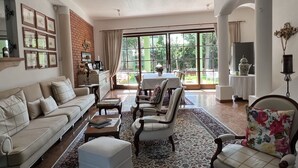 A spacious living room with a large window, a sofa, chairs, and a coffee table. - Dietrichsteinerhof Apartments & Rooms (Finkenstein am Faaker See)
