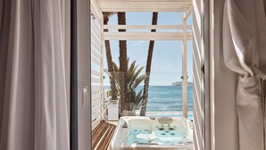 Zona de spa con bañera de hidromasaje y vistas al mar.