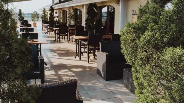 An outdoor café area with tables and chairs, surrounded by greenery. - Gosterisli Hotel (Düzce)