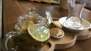 A wooden table with a glass teapot, a glass pitcher, and a tray with biscuits. - Gosterisli Hotel (Düzce)