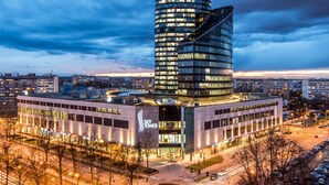 A modern building with a curved facade and a Sky Tower sign. - In The Sky - Sky Tower Apartments (Wroclaw)