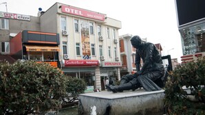 A statue of a seated figure in a public square with a building labeled "OTEL Şaban ACIĞKÖZ" in the background. - Saban Acikgoz Hotel (Edirne)