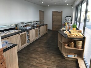 Una cocina moderna con alacenas de madera, encimera negra y una variedad de alimentos para el desayuno.