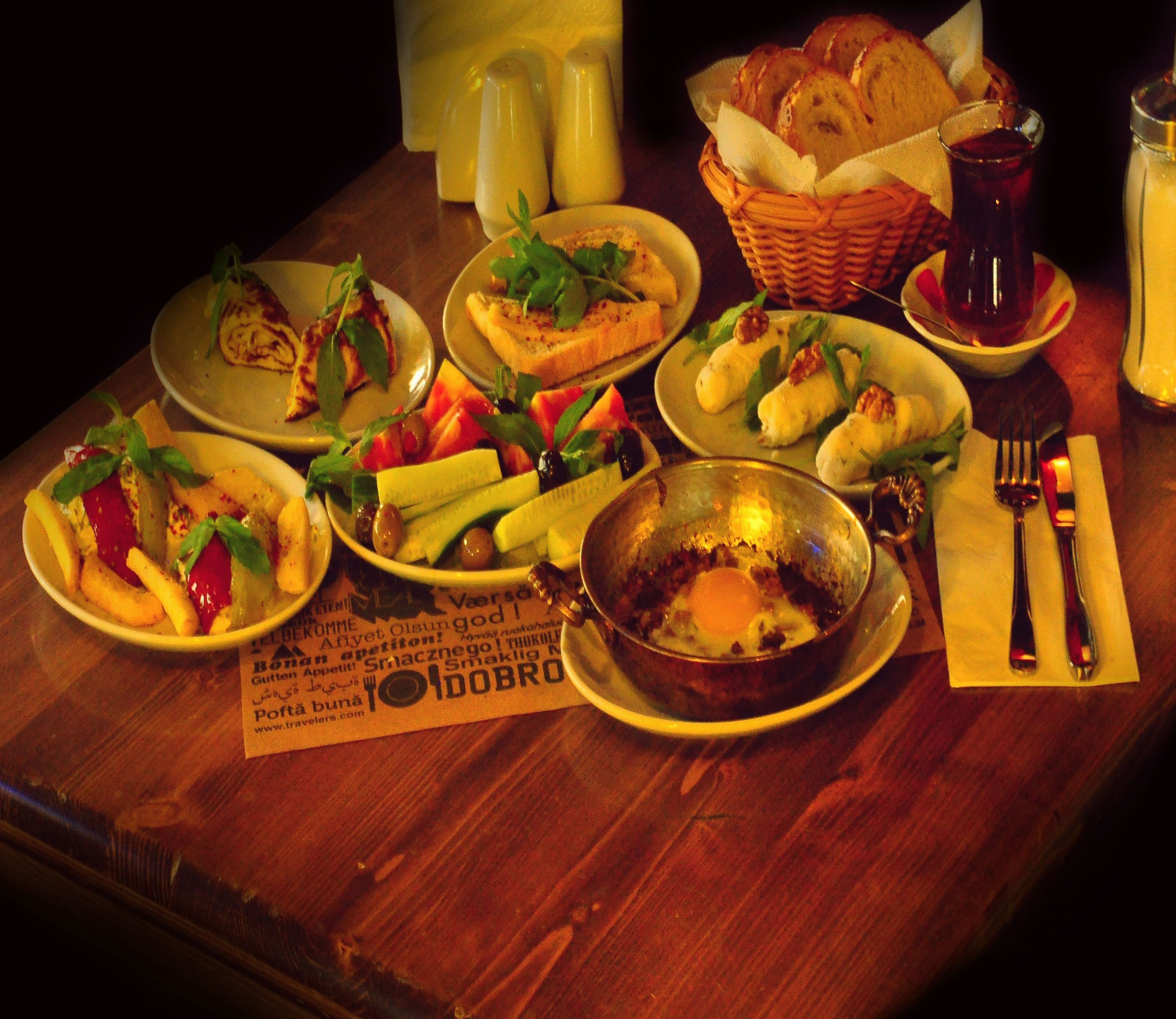 A table set with various dishes including bread, salads, and a bowl of eggs.