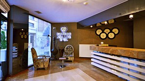 A hotel reception area with a reception desk, a chair, a wall clock, and a sign that reads "ESKISEHIR ADA LIFE HOTEL". - Ada Life (Eskisehir)