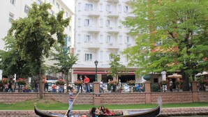 A gondola on a canal with a building in the background. - Ada Life (Eskisehir)