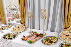 A buffet table with various food items and decorative elements.