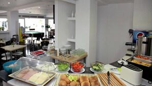 A buffet setup with various food items, a coffee machine, and a toaster. - Mimosa Suites (Rhodes)