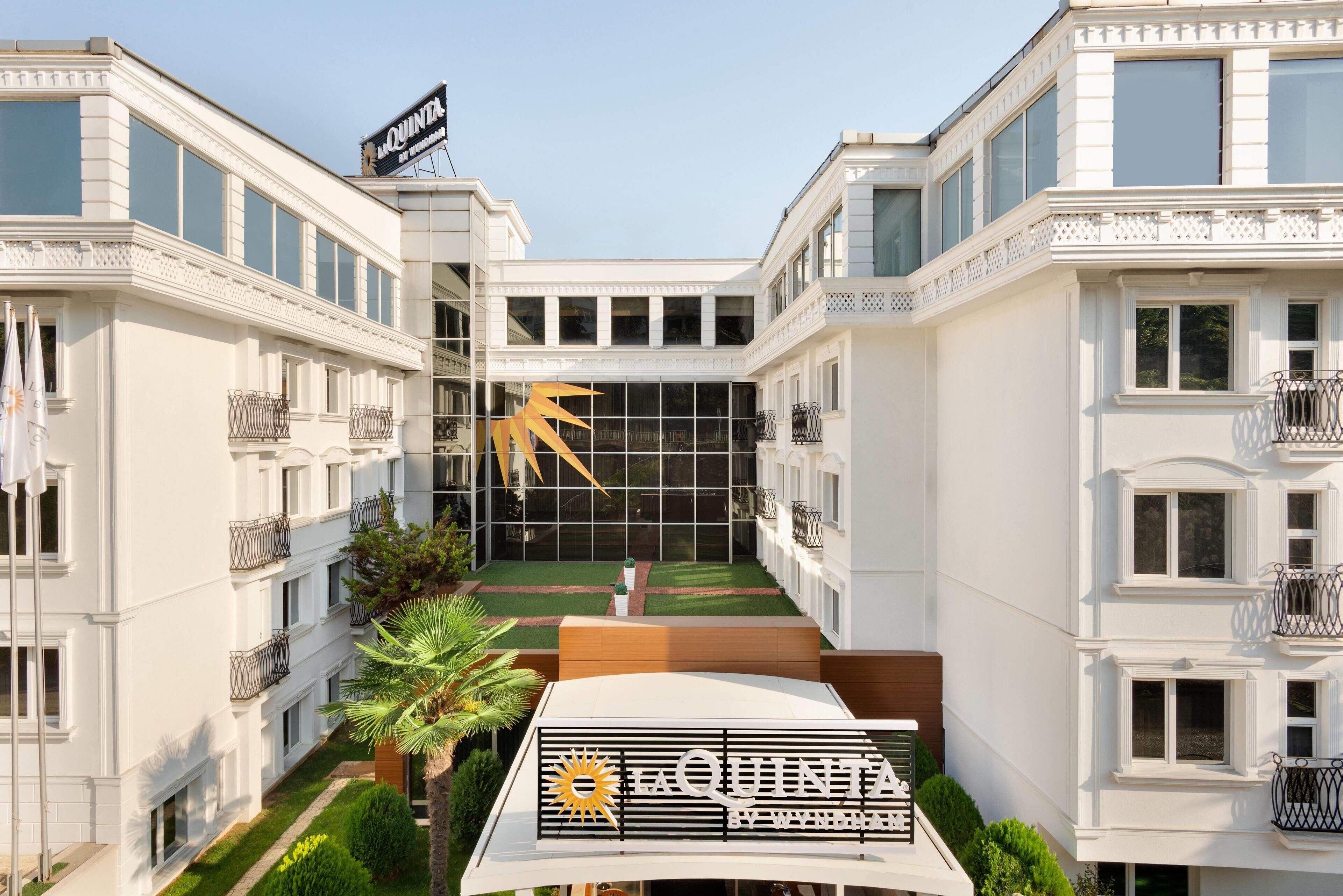 Un hotel amb un pati central, balcons i un rètol que diu "La Quinta by Wyndham".