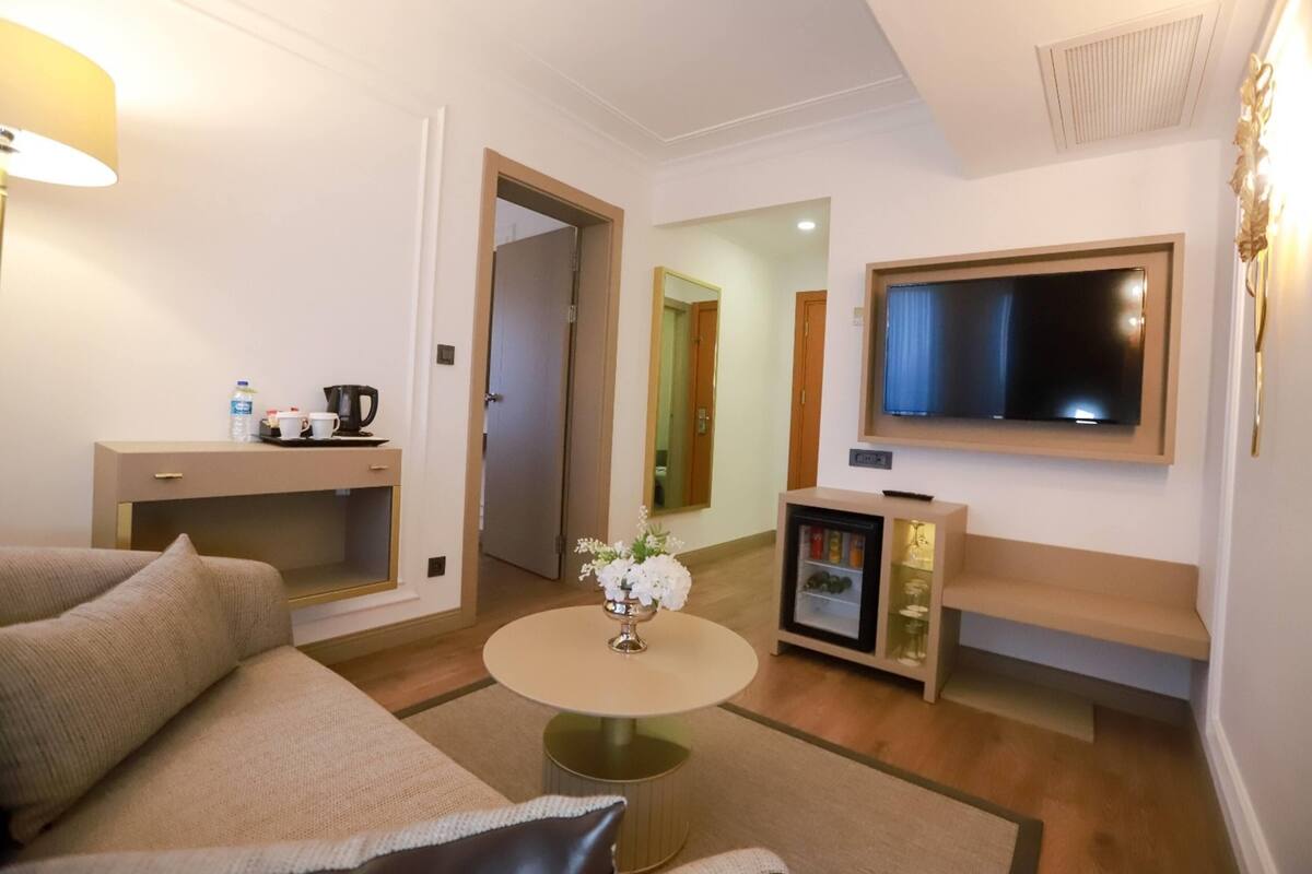 Ein modernes Wohnzimmer mit einer Couch, einem Couchtisch, einem Fernseher und einem kleinen Schrank.