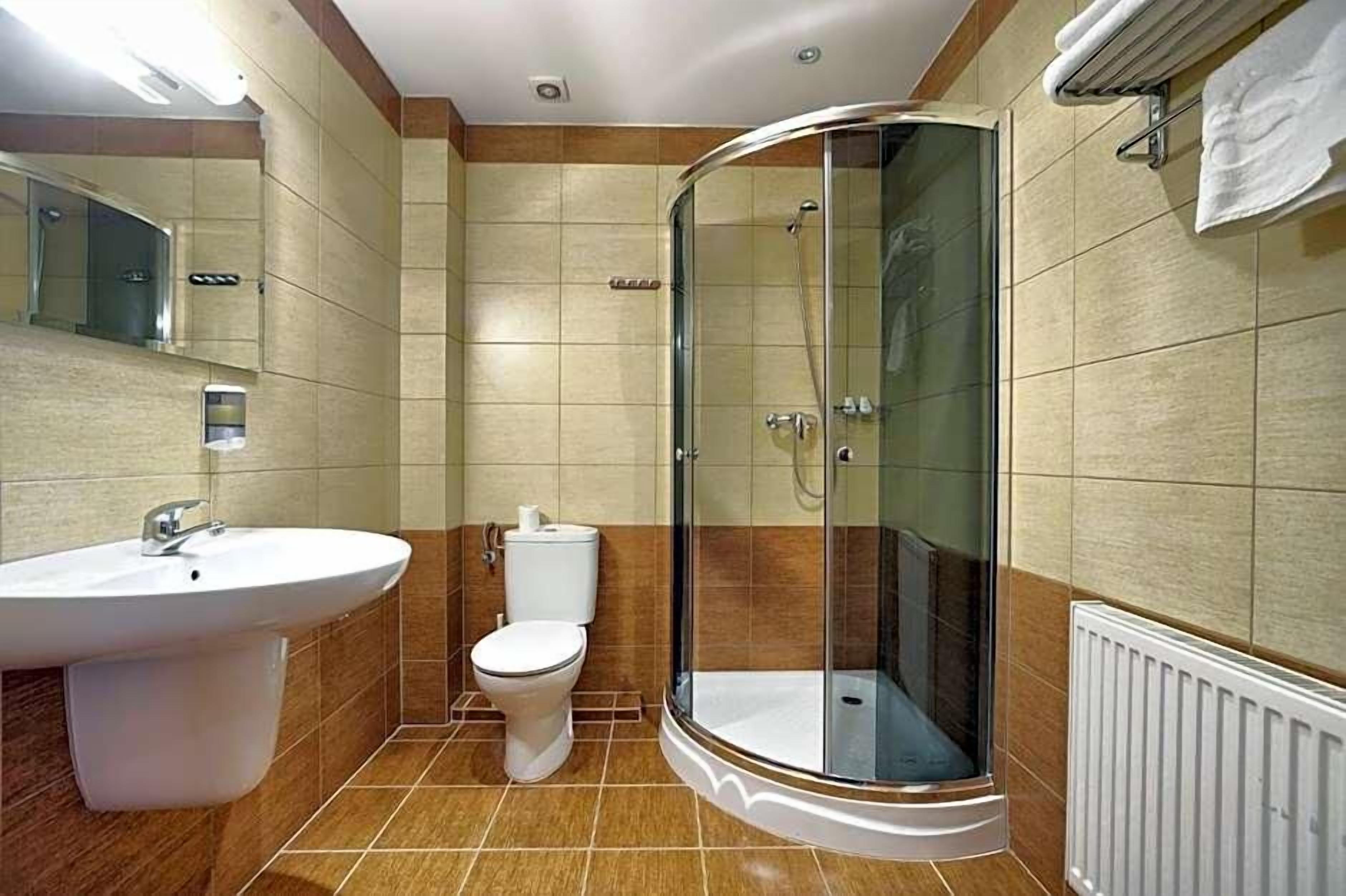 Ein Badezimmer mit Duschkabine, Waschbecken und Toilette.
