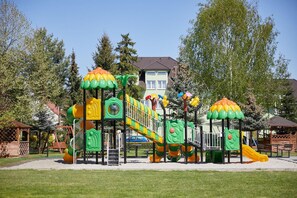 A playground with multiple play structures including slides and climbing areas.