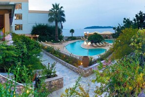 A pool area with lounge chairs and a view of the sea. - Esperides (Skiathos)