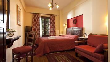 A hotel room with a bed, a chair, a desk, a television, and a window with curtains.