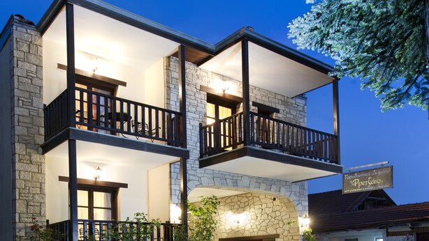 A two-story building with a stone facade, balconies, and a stone fireplace. - Fretzato Traditional Guest House (Pyli)