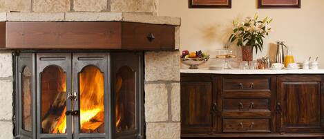A stone fireplace with a modern design, wooden cabinets below, and a decorative rug on the floor.