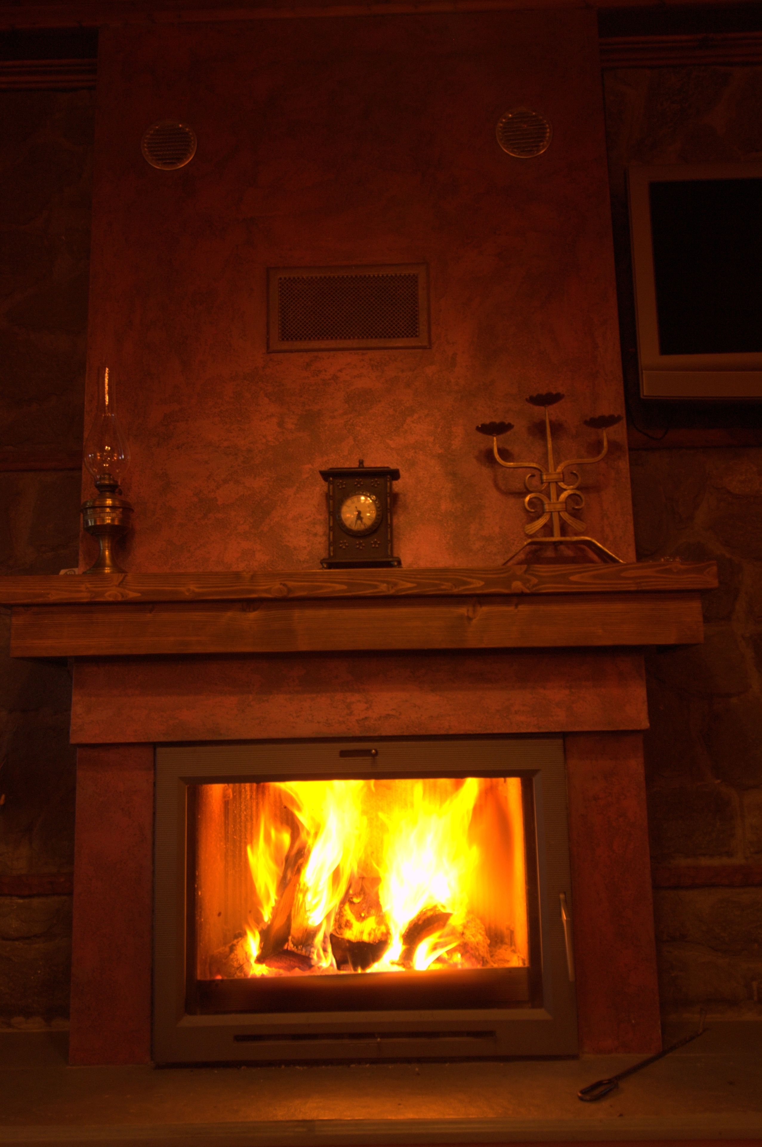 A fireplace with a clock and candelabra on the mantel.