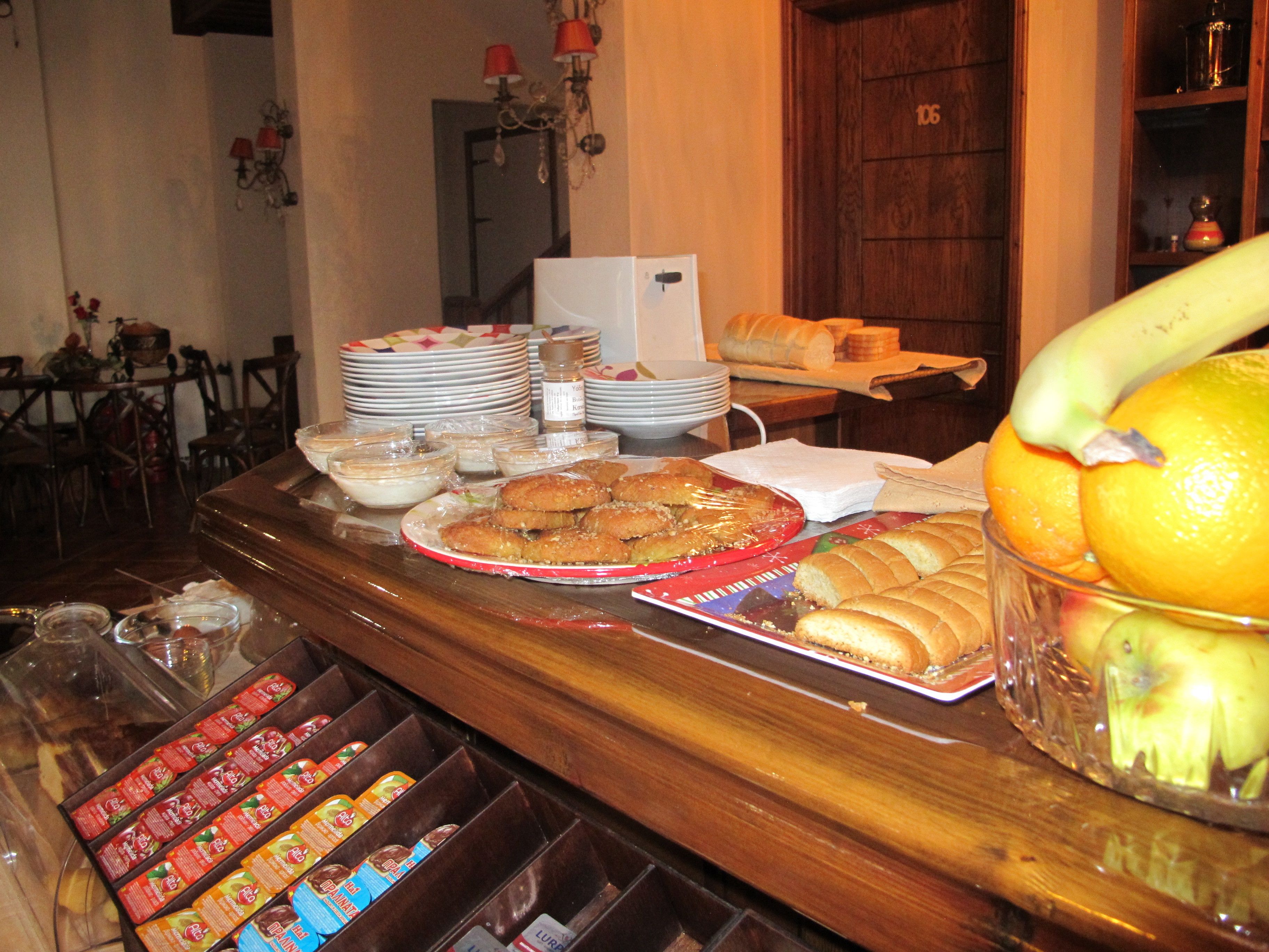 A buffet table with various food items, including pastries, bread, and fruits.