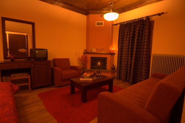 Una sala de estar acogedora con chimenea, televisor y una alfombra roja.