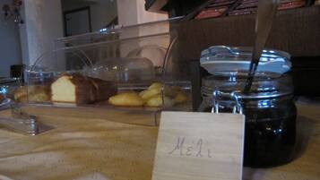 A breakfast counter with a variety of pastries and a jar of jam.